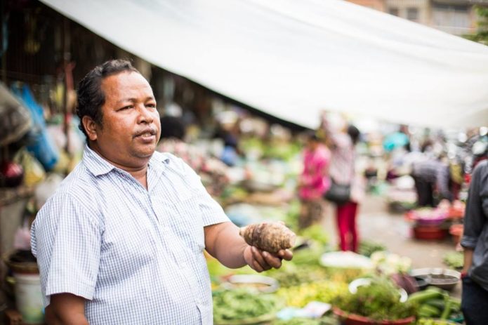 Cambodian man selling food in Battambang food market.