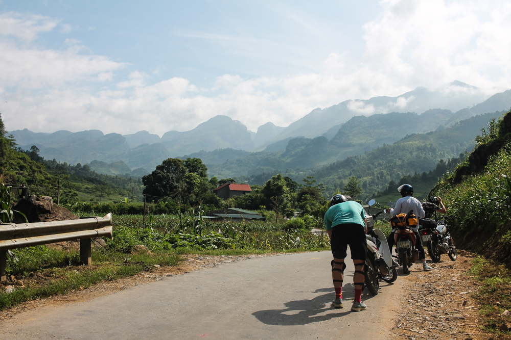 person adjusts motorbike on the side of road
