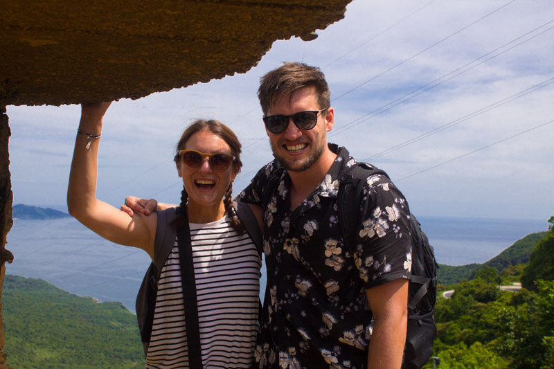 man and woman standing with ocean in background