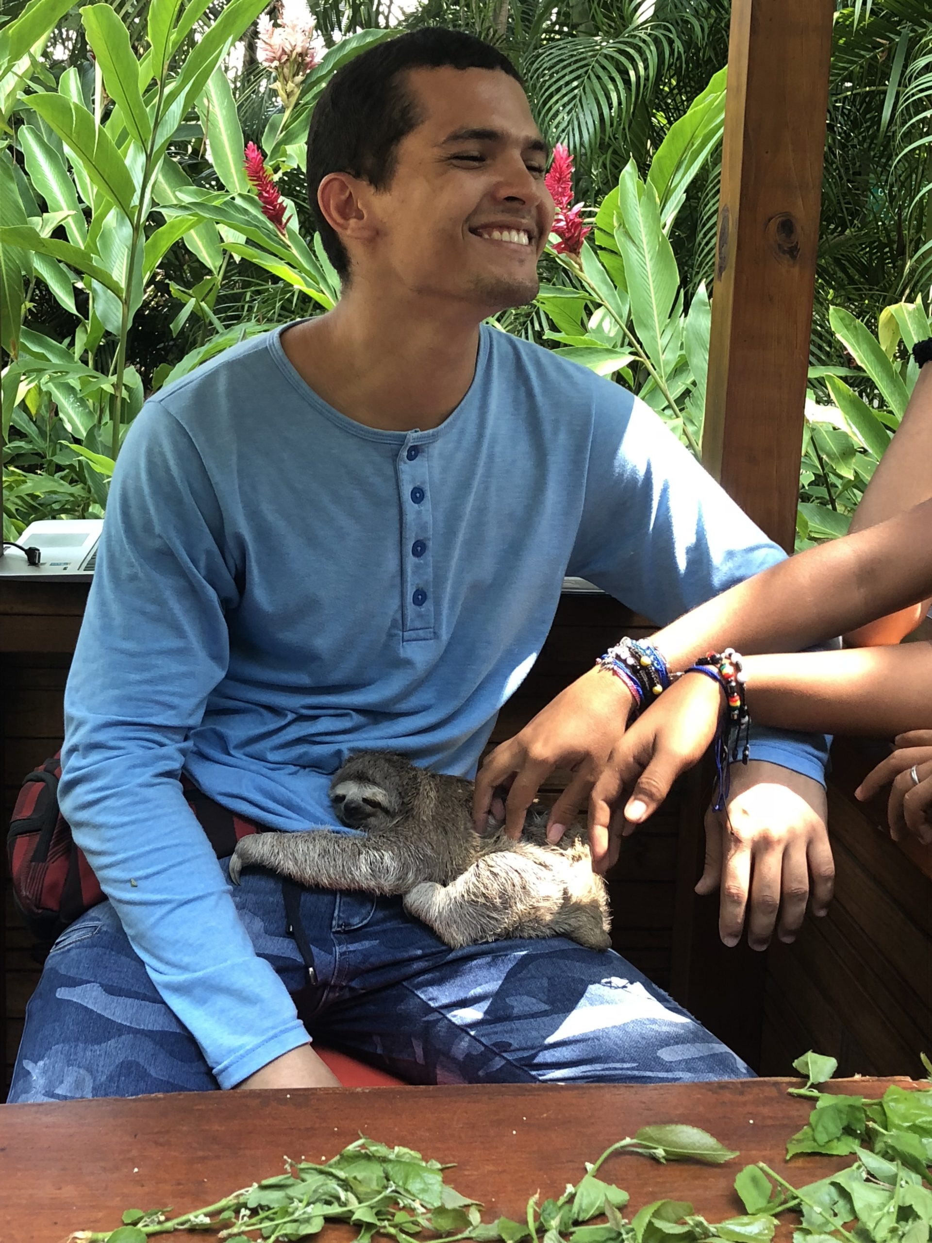 man holding sloth on nature reserve
