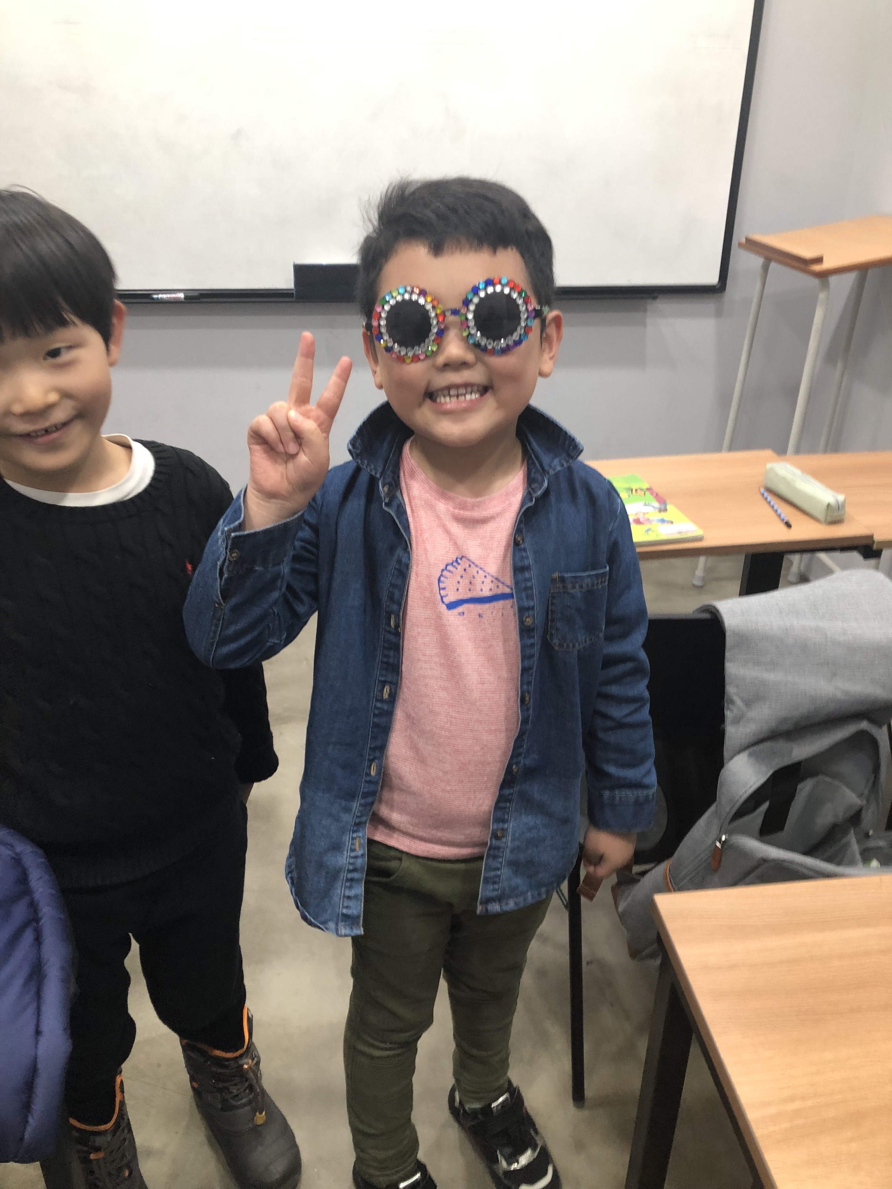 student in classroom making peace sign