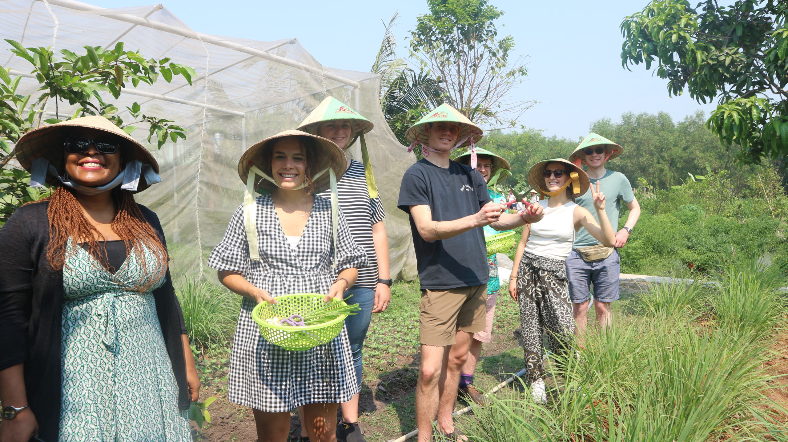 people in conical hats holding produce