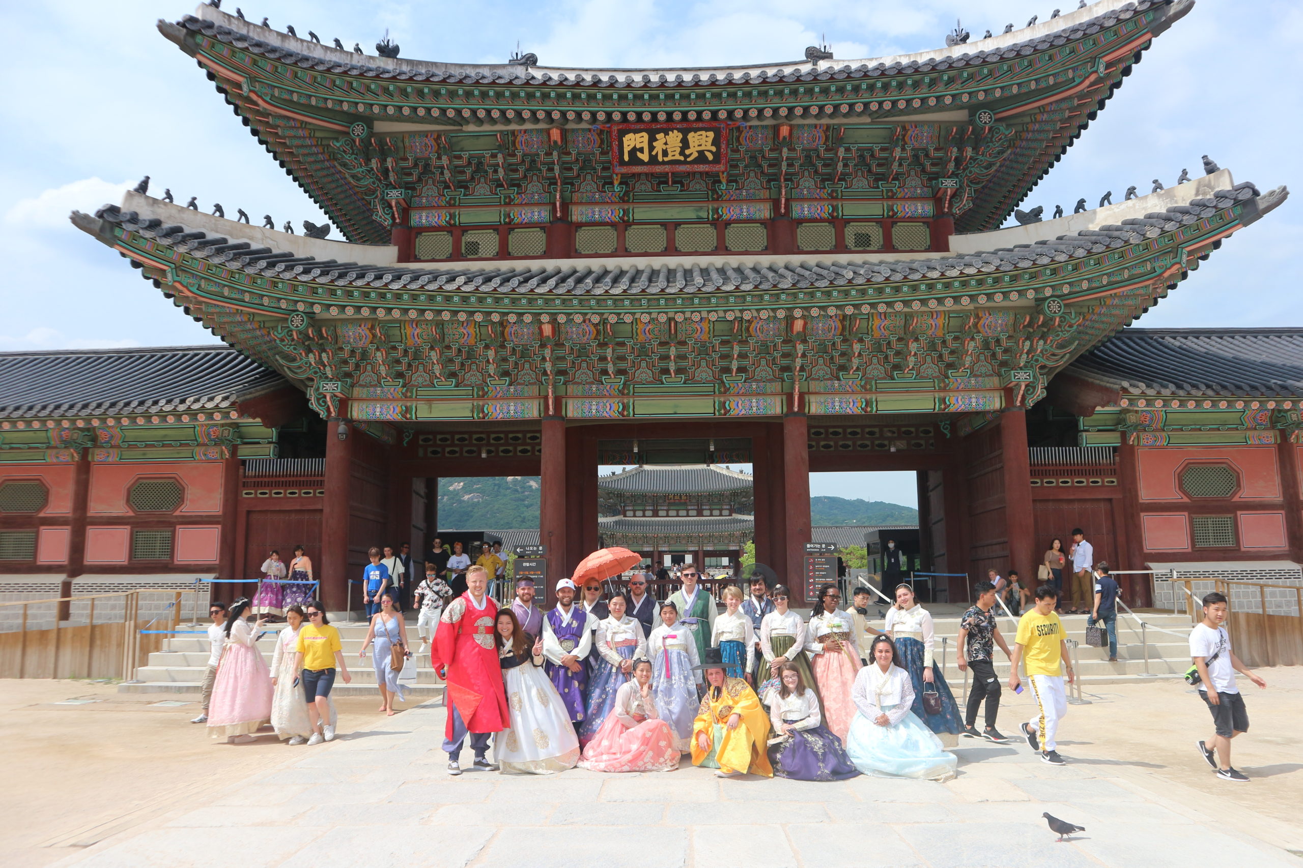 tourists in hanbok in front of Korean palace