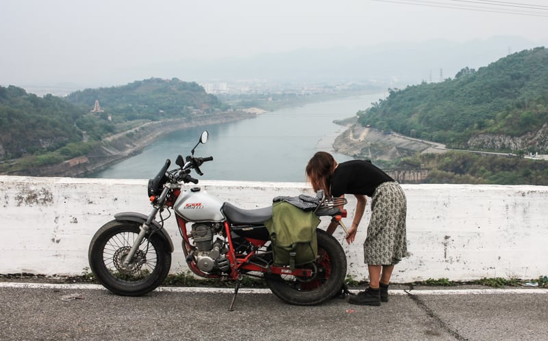 woman arranging bags on motorcycle