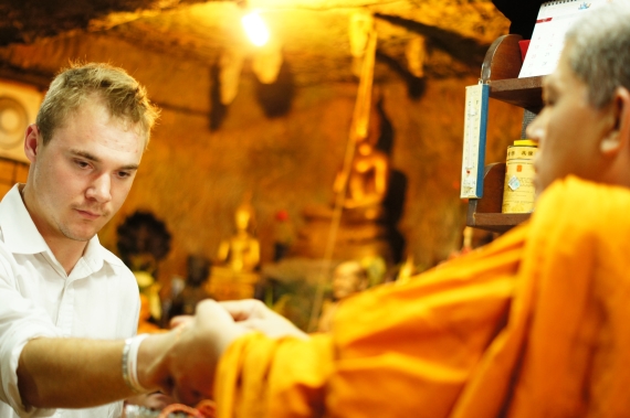 Westerners receive a blessing from a Buddhist monk in Thailand