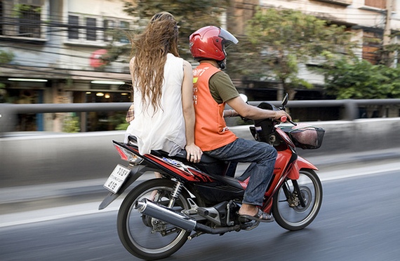 Westerner getting around Bangkok on a motorcycle taxi