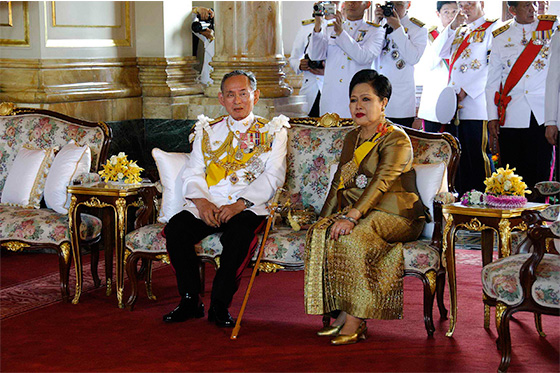 The king and queen of Thailand pose for a photo in the royal palace