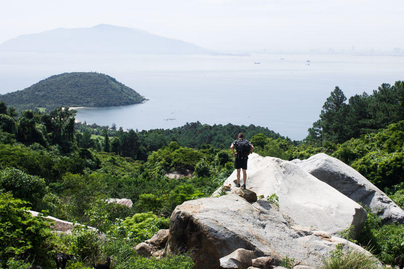 English teacher in Vietnam standing on a boulder overlooking Da Nang beaches