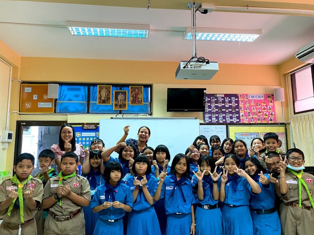 teacher and class of students pose in classroom