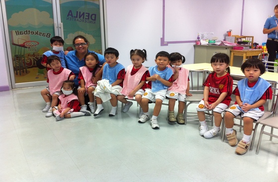 Western English teacher with her kindergartern students in Thailand