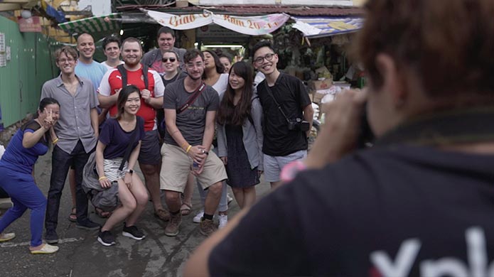 Participants pose for a group photo at a Vietnamese food market.