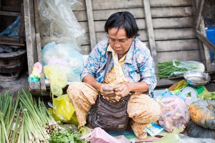 Cambodian woman selling fresh produce at local food market in Battambang