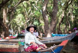 A very cheerful Cambodia womantransporting tourists through the floating village of Kompong Phluk.
