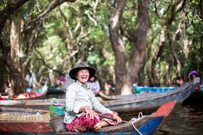 A very cheerful Cambodia womantransporting tourists through the floating village of Kompong Phluk. 