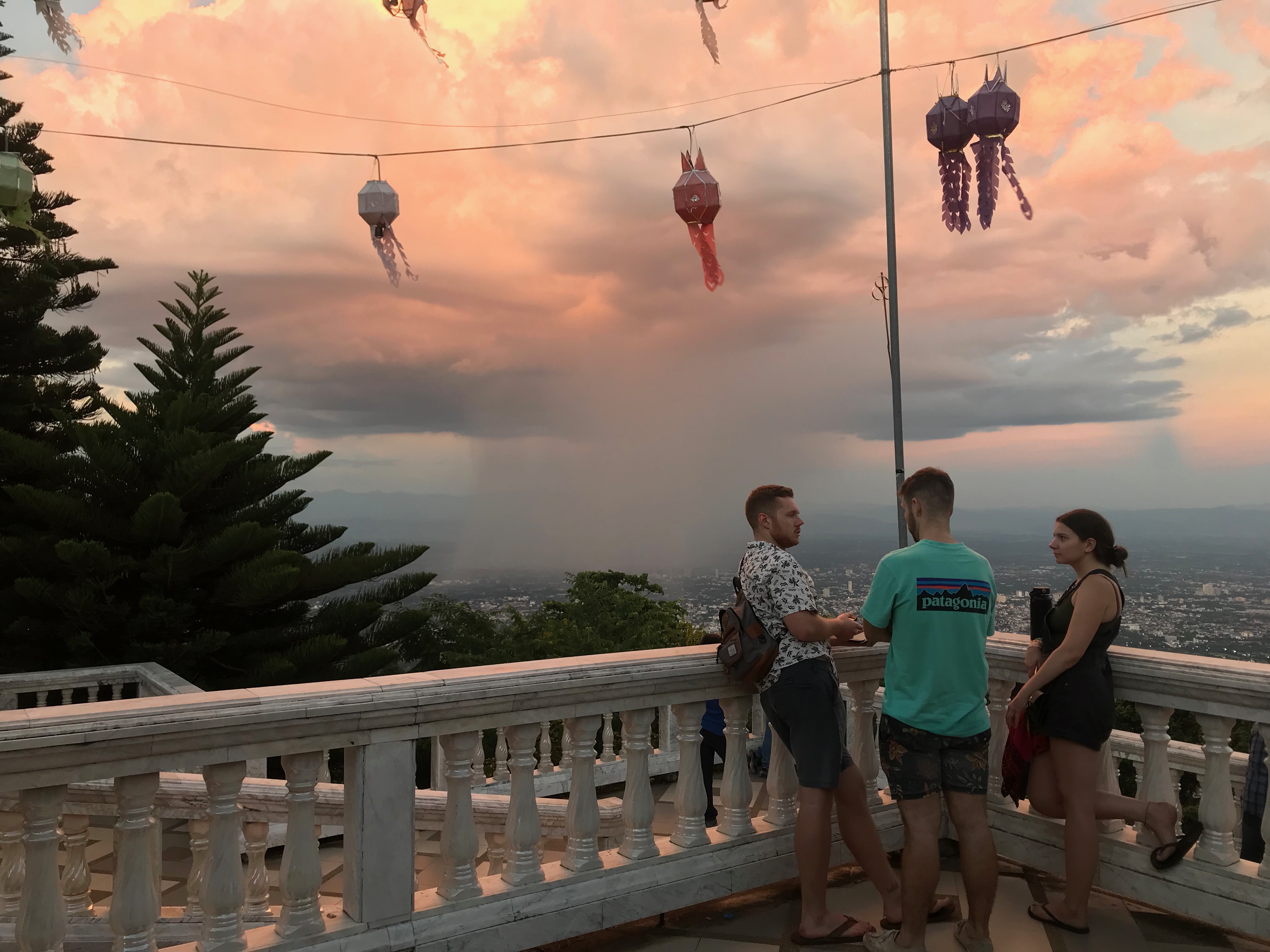 friends talking on a balcony at sunset