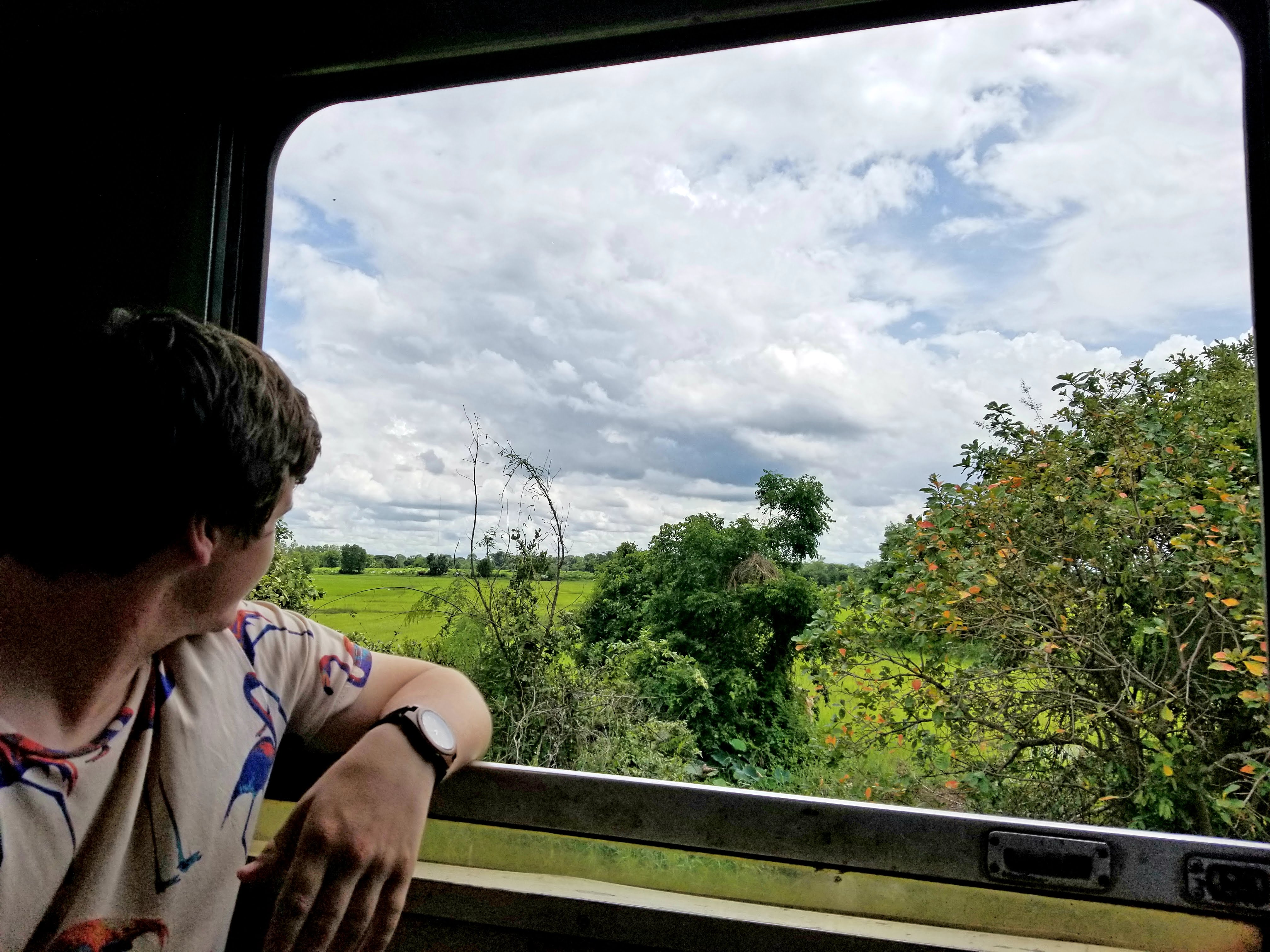 man looks out from train window
