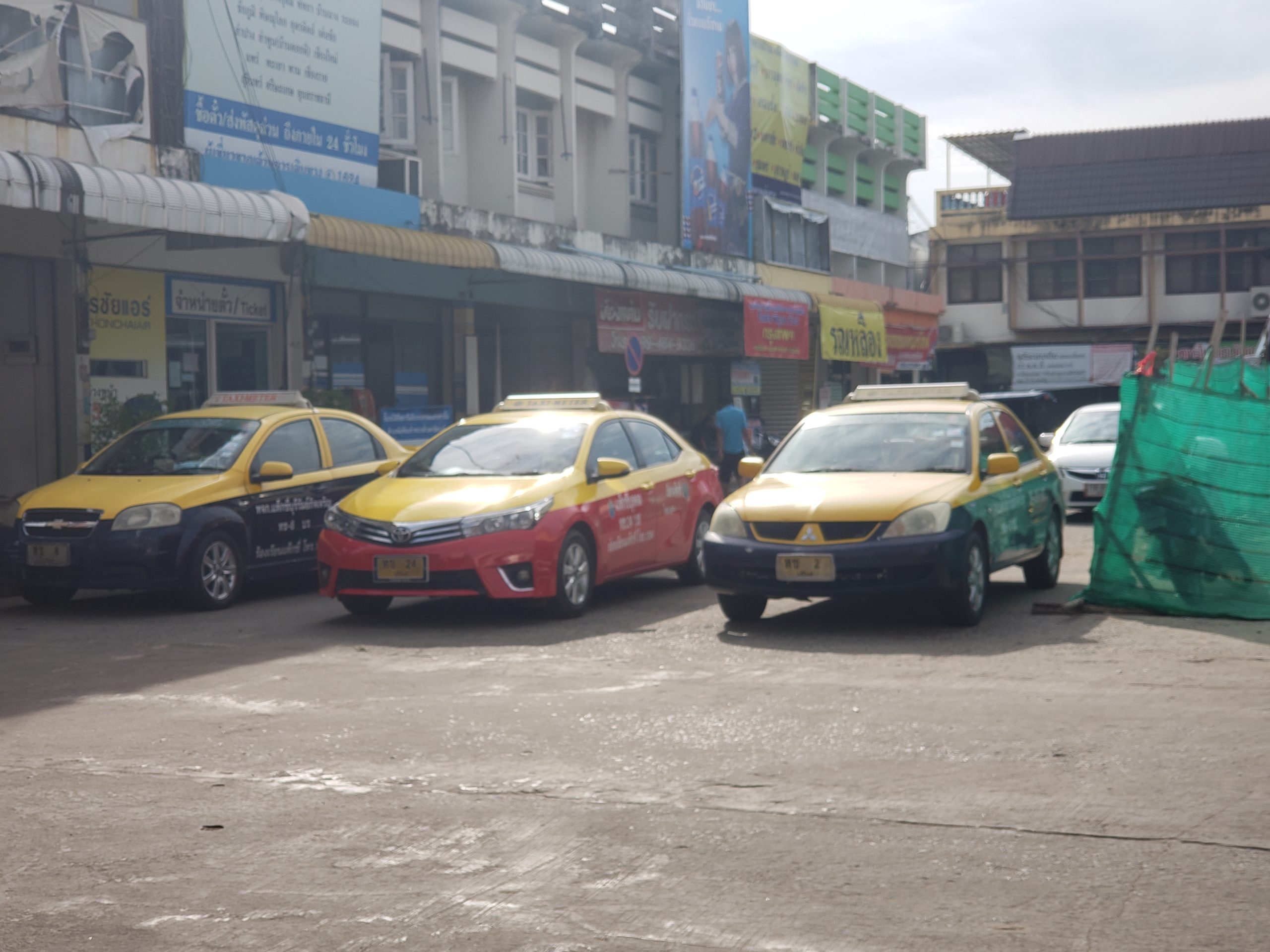 pink, yellow, and green taxis in Thailand