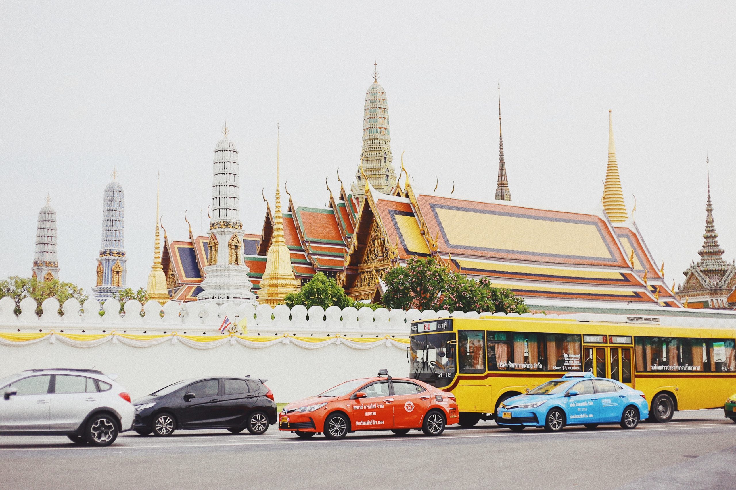 taxis and busses in front of Thai temple