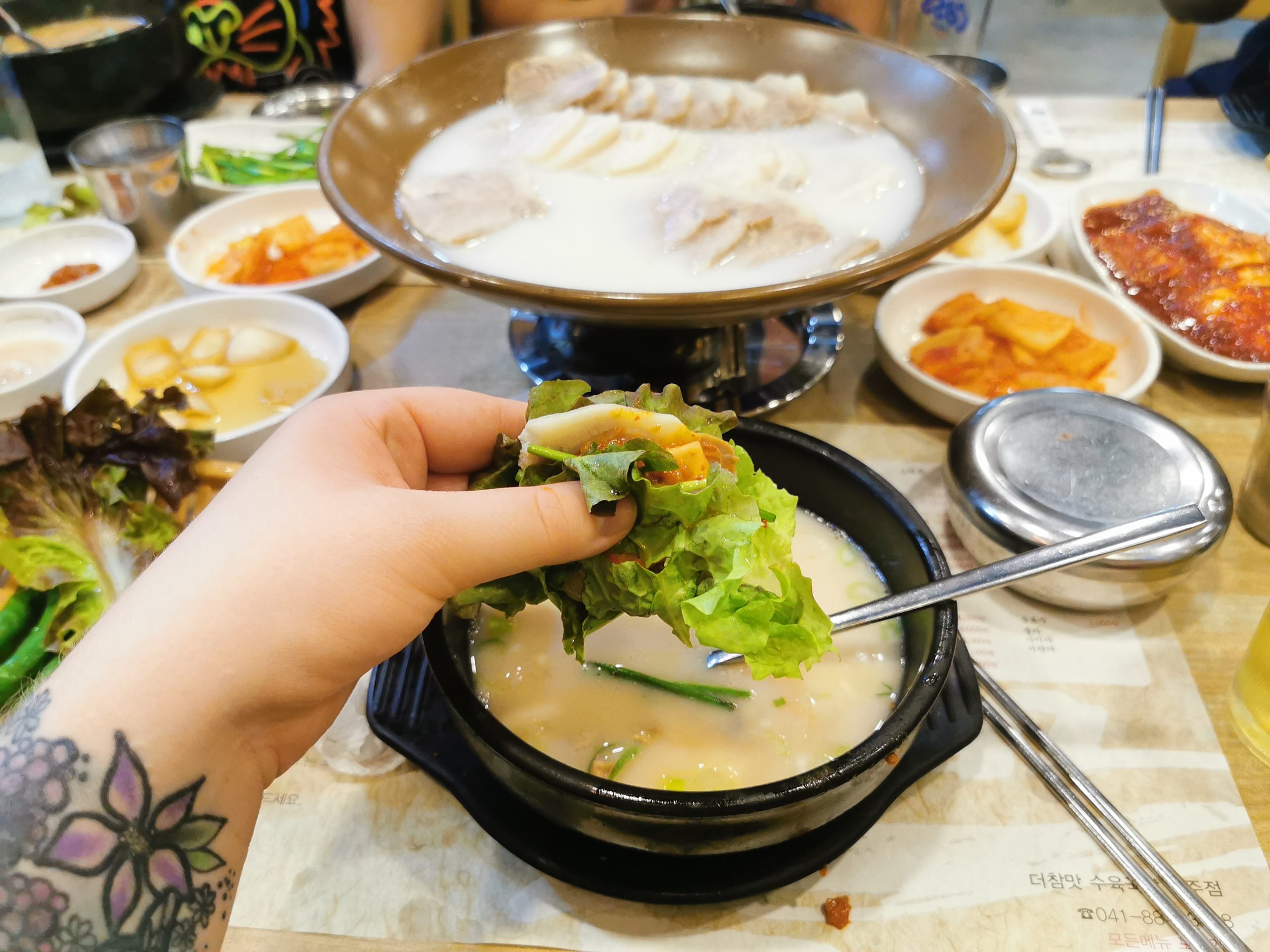 hand holding food over hot pot
