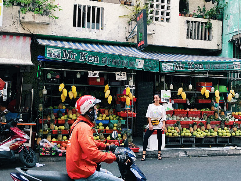 Aubrey infront of fruit stand in Vietnam